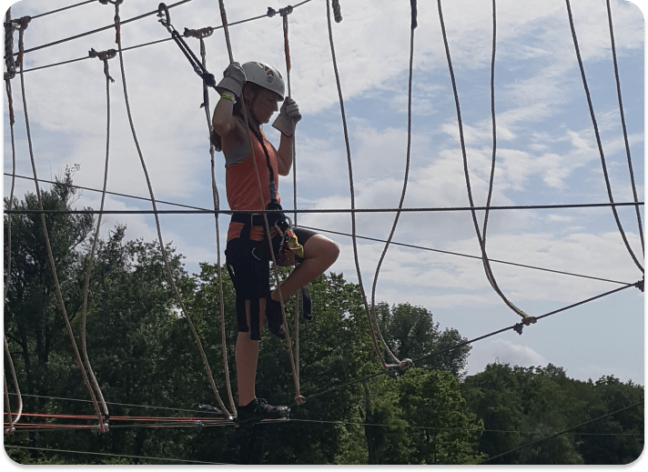 Person walking through the ropes of an aerial obstacle course