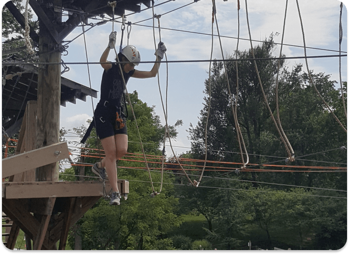 person working their way through an aerial obstacle course