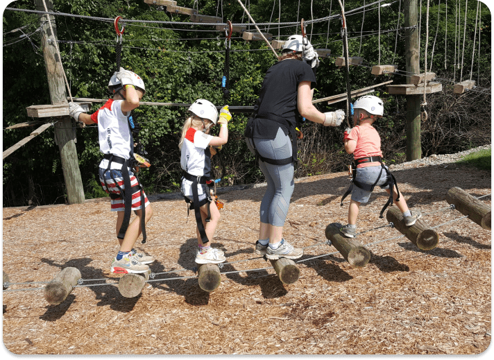 kids walking across aerial challenge course bridge