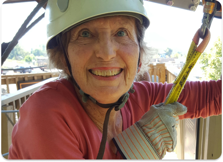 lady posing for the camera getting ready to go on a zip line course