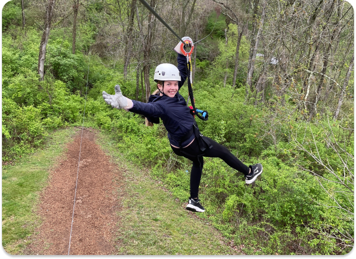 person posing for the camera while on a zip line course